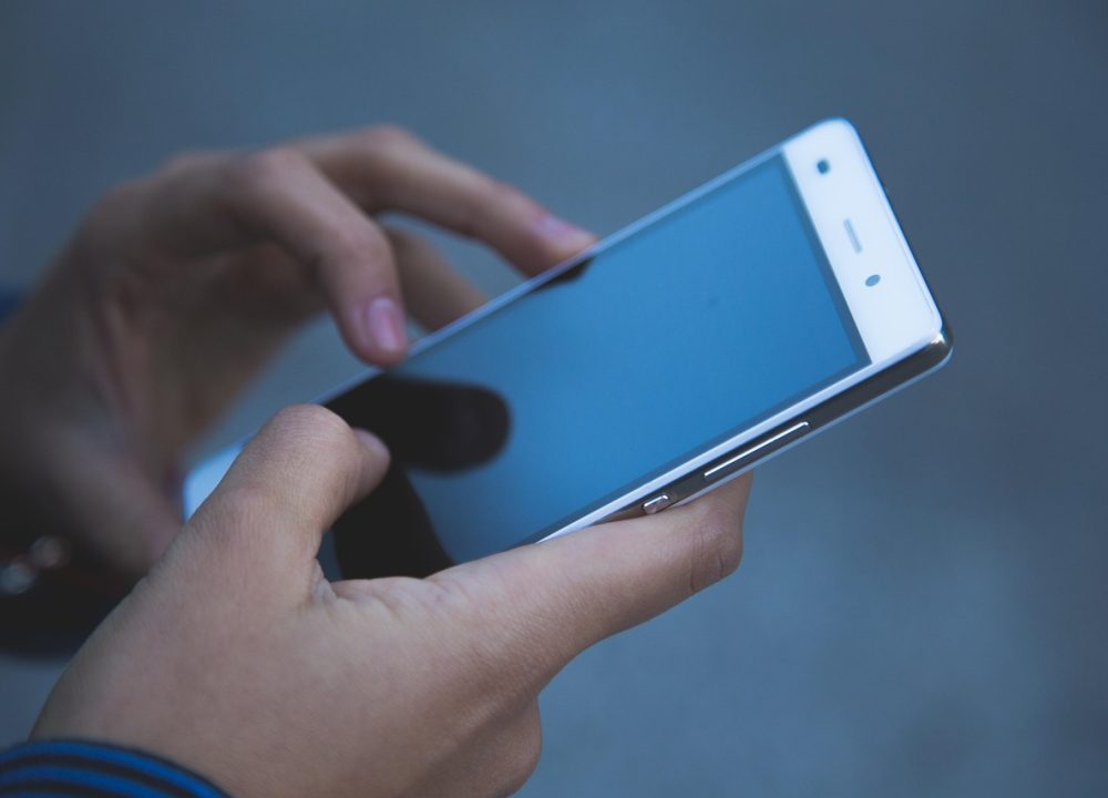 用户在通勤地铁上单手操作手机，屏幕显示简历模板下载 App 的段落改写提示面板，给出三个不同长度的表述选项